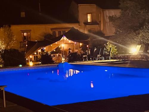 a pool with blue lighting in front of a house at Domaine Du Castellas in Saint-Raphaël