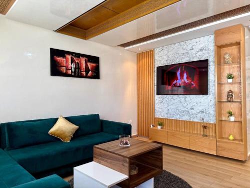 a living room with a green couch and a tv at Modern Duplex in Downtown with Netflix & IPTV in Kenitra