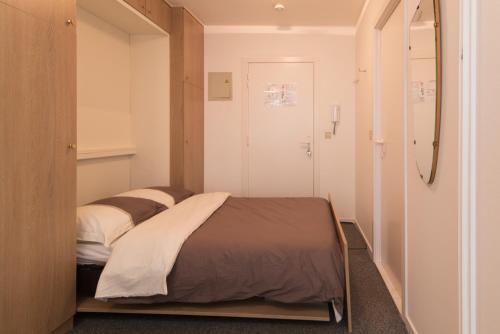 une chambre avec un lit dans une petite pièce dans l'établissement Atlantic 11A, à Ostende