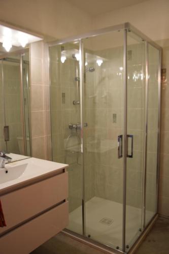 a glass shower in a bathroom with a sink at Chambres d'Hôtes L'Orée des Bois in Lacrouzette