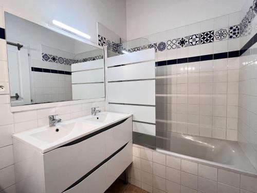 une salle de bain blanche avec un lavabo et une baignoire dans l'établissement ABYS Logement avec grande terrasse, à Saint-Martin-de-Ré
