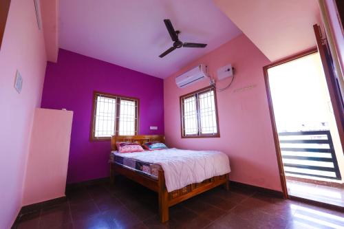 a bedroom with purple walls and a bed at MV Homestay in Sriperumbudur