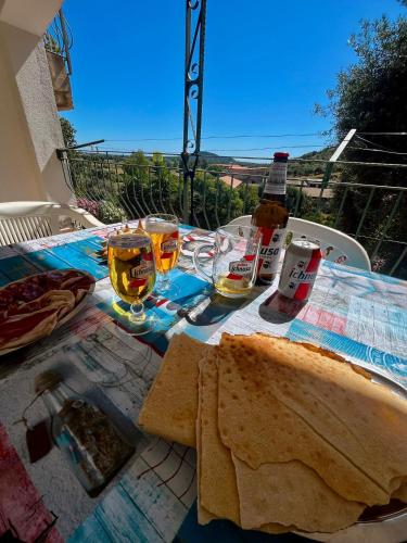 a table with a sandwich and glasses of wine at Appartamento Sa Funtana in Cardedu
