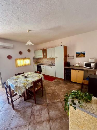 a living room with a table and a kitchen at Appartamento Sa Funtana in Cardedu