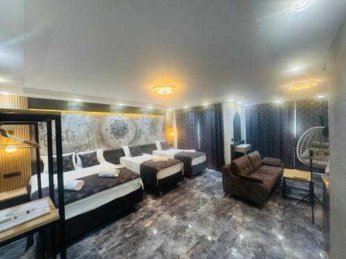 a hotel room with two beds and a couch at Tikir House in Pamukkale