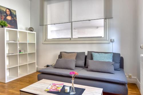 un salon avec un canapé bleu et une table dans l'établissement Le Alain charmant duplex au cœur de Rouen, à Rouen