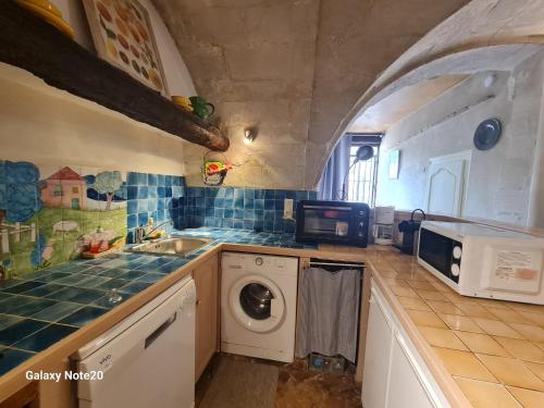une cuisine avec un évier et une machine à laver dans l'établissement Maison de charme Villeneuve les Avignon, à Villeneuve-lès-Avignon