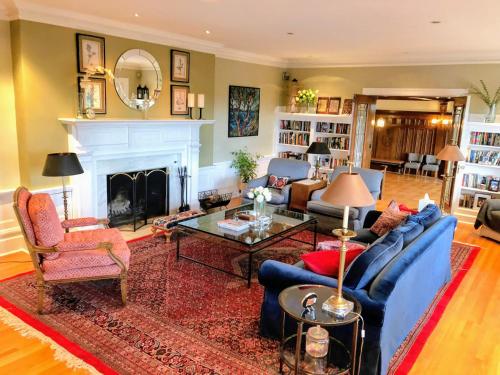 a living room with a blue couch and a fireplace at Shaughnessy Heritage Manor on Vancouver's Westside free housekeeping optional in Vancouver