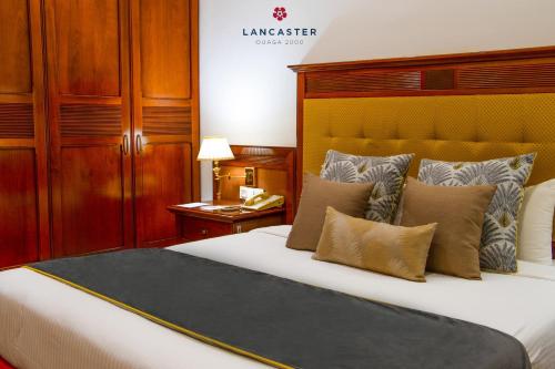 a bedroom with a large bed and wooden cabinets at Lancaster Ouaga 2000 in Ouagadougou