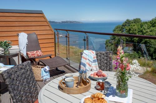 a table with a tray of food on a balcony at Lapwing 2, The Cove, Waterfront Apartment in Brixham