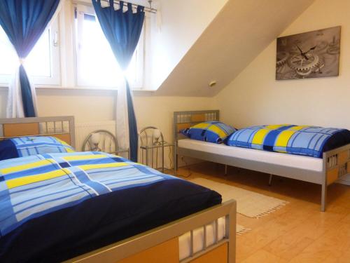 een slaapkamer met twee bedden met blauw en geel bij Airport Apartment in Düsseldorf