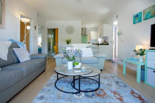 a living room with a couch and a table at Lapwing 2, The Cove, Waterfront Apartment in Brixham