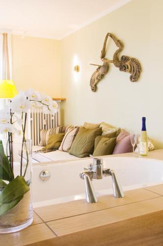 a bathroom with a bath tub with a couch at Hotel Viva Sky in Konstanz