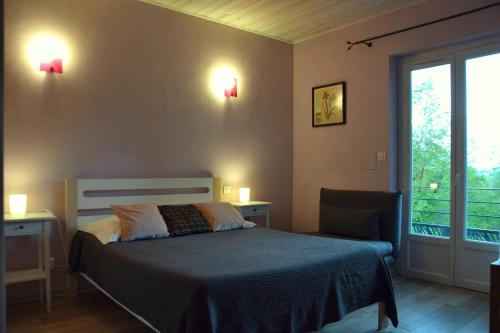 a bedroom with a bed and two lights on the wall at Chambres d'Hôtes L'Orée des Bois in Lacrouzette