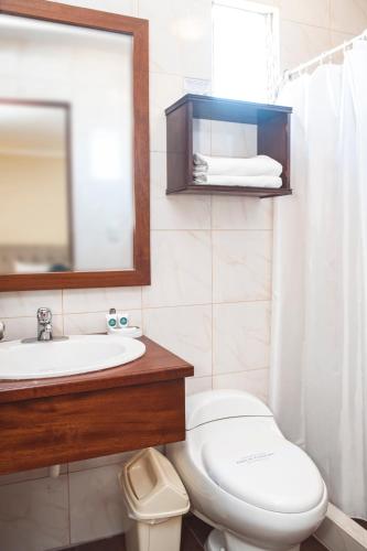 ein Badezimmer mit Waschbecken, Toilette und Spiegel in der Unterkunft Hostal Lirium in Arequipa