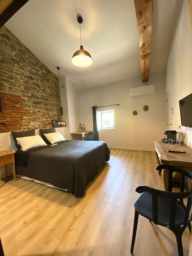 une chambre avec un lit et un mur de briques dans l'établissement Chambres d hôtes La clé des arches, à Sainte-Florine