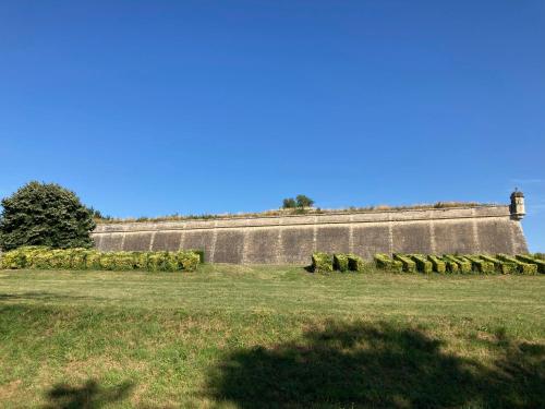 un mur avec des balles de foin dans un champ dans l'établissement Grand Duplex avec terrasse au cœur de Blaye, à Blaye