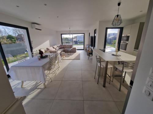 Il comprend une cuisine et un salon avec des tables et un canapé. dans l'établissement La villa Dorée, à Sérignan