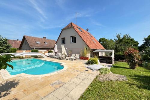 ein Hinterhof mit einem Swimmingpool und einem Haus in der Unterkunft Soh Rent Maison - Villa Piscine Proche Strasbourg - TV - Wifi - Parking in Lampertheim