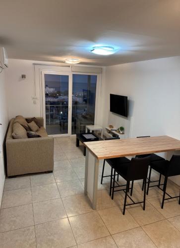 a living room with a table and a couch at Torre Orca Piso 9 Mareas del Golfo in Las Grutas