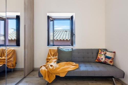 a living room with a couch and two windows at GuestHost - My Little Pink House in Selargius