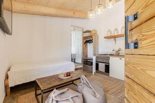 a kitchen and a bedroom with a bed and a table at Rustic cabin with pond and deck in Aljezur