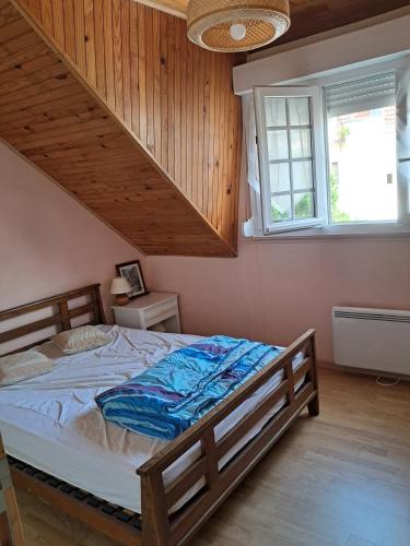 une chambre avec un grand lit avec un plafond en bois dans l'établissement Le Marquenterre, à Quend-Plage