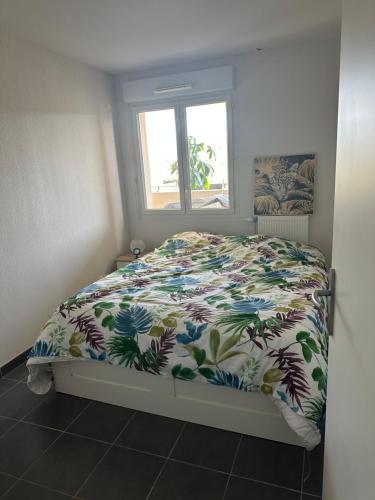 une chambre avec un lit avec une couette colorée dans l'établissement résidence proche de la mer, à Port-de-Bouc