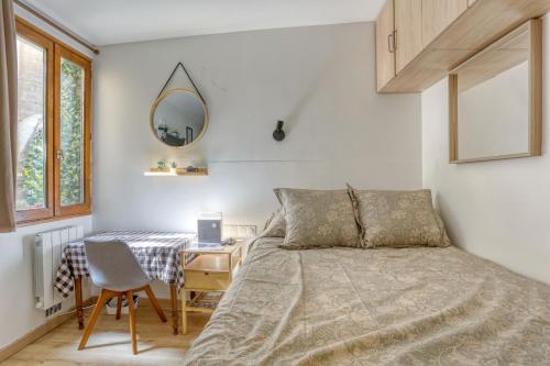 une chambre avec un lit, un bureau et un miroir dans l'établissement Le Lully - Versailles, à Versailles