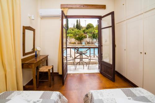 a bedroom with a door leading to a balcony at Amarandos Rethimno's Villa in Roussospítion