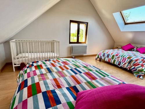 a attic bedroom with two beds and a window at Chez Raoul, maison agréable in Villebernier