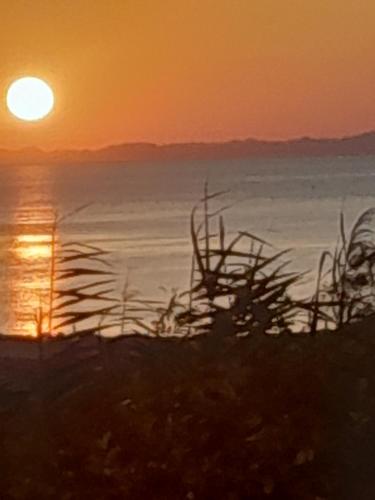 a sunset over the ocean with the sun setting at Osiris Guest House in Abu Simbel