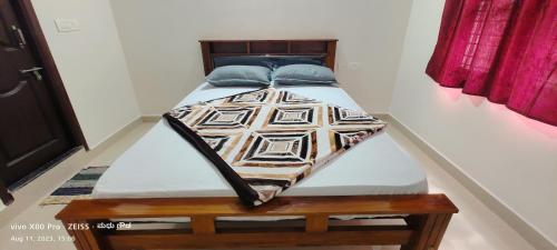 a bed with blue pillows on it in a room at thotadamane easystay in Chikmagalur