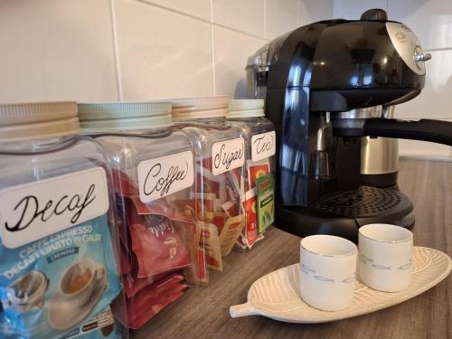 a counter with cups of food and a coffee maker at Classic Home Porto Maurizio in Imperia