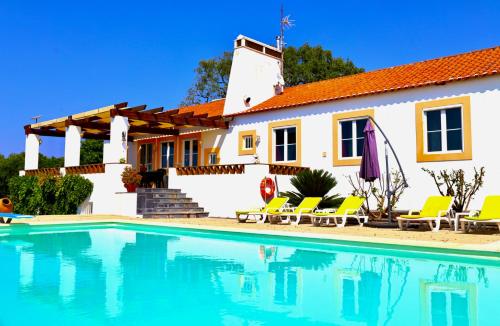 a villa with a swimming pool in front of a house at Monte da Casa Telhada in Santiago do Cacém