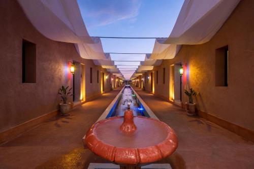 a hallway with a table in the middle of a building at Al destino Resort Marrakech in Marrakech