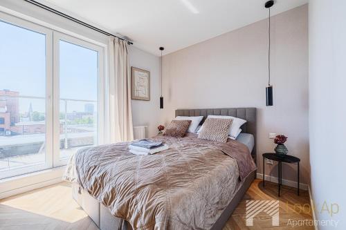 a bedroom with a bed with a large window at Slovianka Sky View by LookAp darmowy parking!! in Łódź