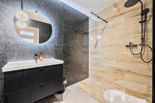a bathroom with a sink and a shower at Slovianka Sky View by LookAp darmowy parking!! in Łódź