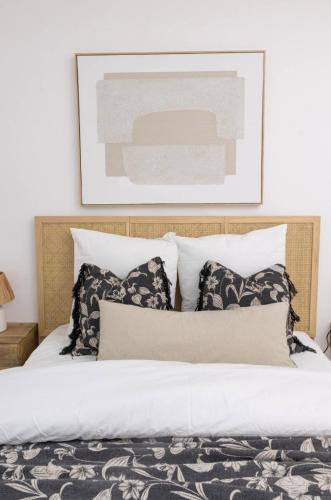 - un lit avec des oreillers en noir et blanc et une photo dans l'établissement Lanova appartement pour 6 proche Disneyland Paris, à Chessy