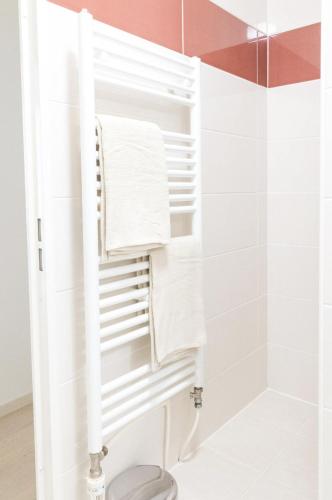 - un porte-serviettes dans la salle de bains pourvue de serviettes blanches dans l'établissement Lanova appartement pour 6 proche Disneyland Paris, à Chessy