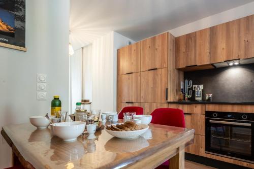 eine Küche mit einem Holztisch mit Schüsseln darauf in der Unterkunft Appartement La Marmotte à Monetier grande terrasse in Le Monêtier-les-Bains
