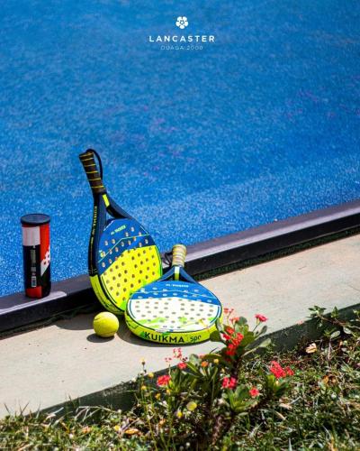 a racket and a tennis ball sitting on a ledge at Lancaster Ouaga 2000 in Ouagadougou