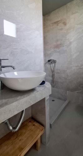 a bathroom with a white sink and a shower at MariGold Villa in Prinos