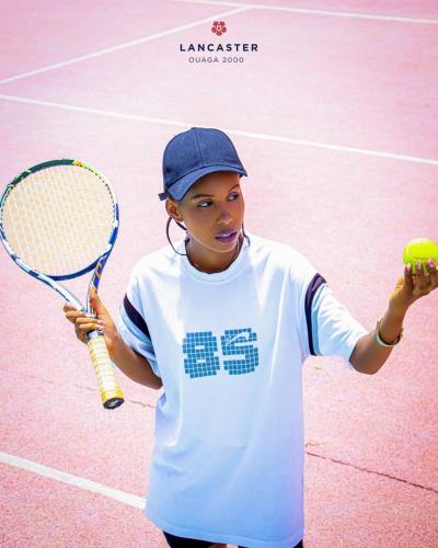 a young boy holding a tennis ball and a racket at Lancaster Ouaga 2000 in Ouagadougou