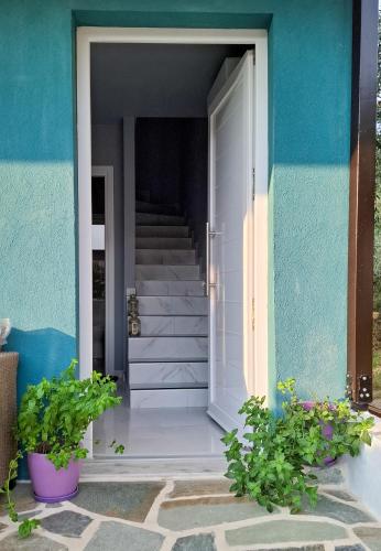 a blue building with a white door and stairs at MariGold Villa in Prinos