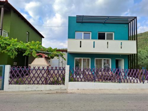 a blue and white house with a fence at MariGold Villa in Prinos