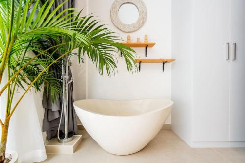 a bathtub in a bathroom with a plant at Sunrise Bliss 2 in Dalung