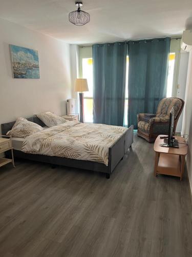 une chambre avec un grand lit et une chaise dans l'établissement appartement 3 pieces 2 chambres centre ville, à Antibes