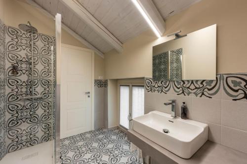 a bathroom with a white sink and a mirror at La casa della Maestra Carolina in Ottiglio
