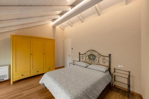 a bedroom with a bed and a yellow cabinet at La casa della Maestra Carolina in Ottiglio